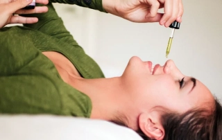 A woman putting nasya oil in her nostrils.